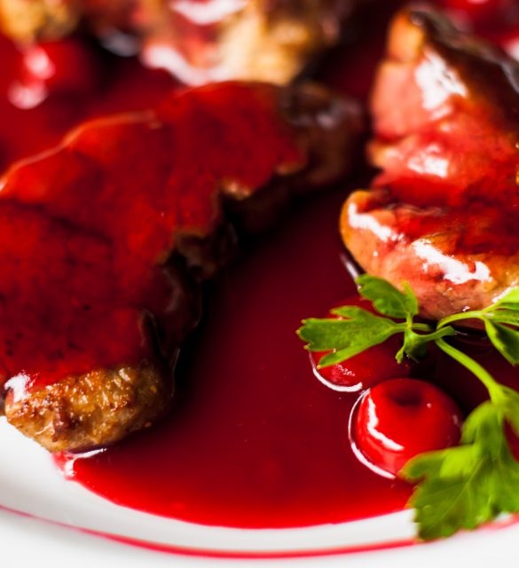 meat with fresh herbs and cherry sauce, ready to eat.