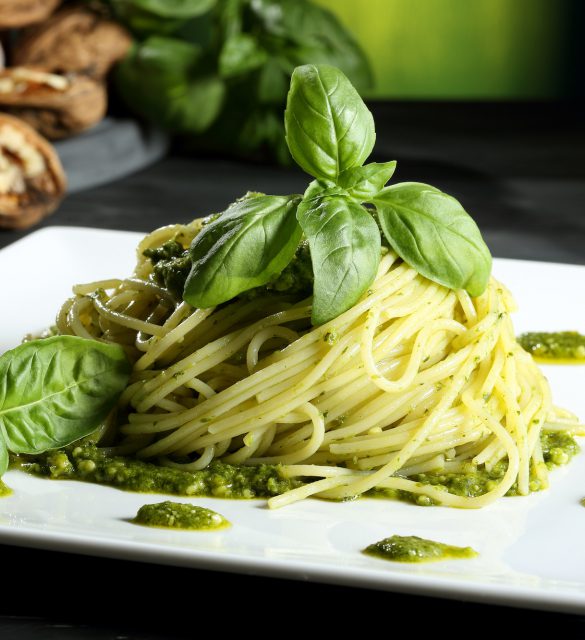 pasta vegetariana spaghetti con pesto sfondo verde