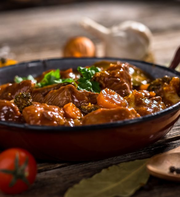 Meat stewed with vegetable on rustic wooden background
